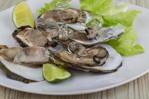 vers oester Aan de bord en houten achtergrond foto