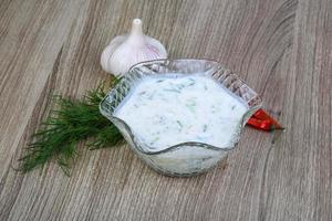 tzatziki in een kom Aan houten achtergrond foto