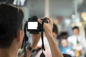 videograaf in de achterkant van camera zijn schreeuwen en opname video in bruiloft evenement. foto