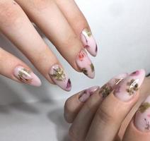 vrouw manicure met bloem ontwerp Aan nagels dichtbij omhoog foto