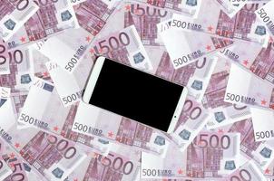 Purper 500 euro geld rekeningen en een smartphone met zwart scherm. kopiëren ruimte. de concept van online bankieren, geld beheer en boodschappen doen met modern technologie foto