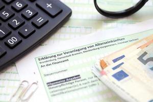 Duitse uitspraak Aan de beoordeling van pensioen inkomen met rekenmachine en Europese geld dichtbij omhoog. de concept van belastingheffing en accountant papierwerk Duitsland foto