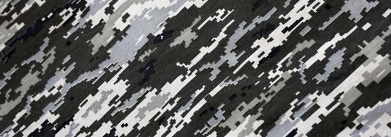 kleding stof met structuur van oekraïens leger korrelig camouflage. kleding met camo patroon in grijs, bruin en groen pixel vormen. officieel uniform van oekraïens soldaten foto