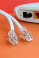 internet router en internet kabel pluggen liggen Aan een helder oranje achtergrond. items verplicht voor internet verbinding foto