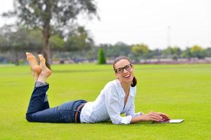 mooi jong vrouw met tablet in park foto