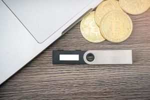 hardware cryptogeld portemonnee met gouden bitcoin btc en computer. veilig opslagruimte voor cryptovaluta. foto