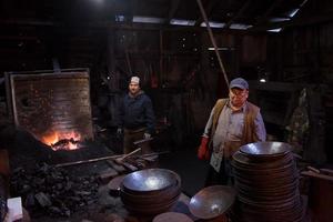 portret van twee generaties traditioneel smid foto