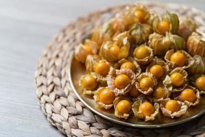 top visie stapel van kaap kruisbes fruit in de goud bord. foto