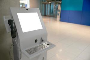 geautomatiseerd informatie machine met bespotten omhoog wit scherm in luchthaven. foto