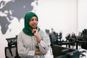 portret van moslim zwart vrouw software ontwikkelaar met groen hijab staand Bij modern Open plan opstarten kantoor. selectief focus foto