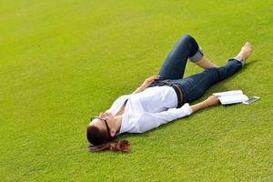 jonge vrouw die een boek in het park leest foto