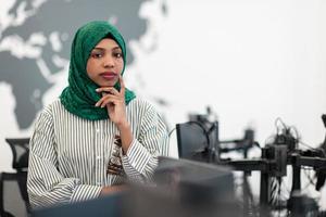 portret van moslim zwart vrouw software ontwikkelaar met groen hijab staand Bij modern Open plan opstarten kantoor. selectief focus foto