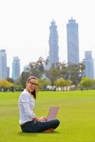 vrouw met laptop in park foto