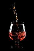 glas cognac op een zwarte achtergrond foto