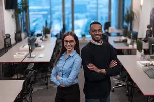 twee gelukkig verschillend professioneel uitvoerend bedrijf team mensen vrouw en Afrikaanse Amerikaans Mens op zoek Bij camera staand in kantoor lobby hal. multicultureel bedrijf managers team portret. foto