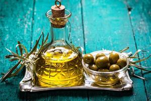 olijfolie en olijven op houten tafel