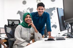 multi-etnisch opstarten bedrijf team Arabisch vrouw vervelend een hijab Aan vergadering in modern Open plan kantoor interieur brainstormen, werken Aan laptop en bureaublad computer. selectief focus foto