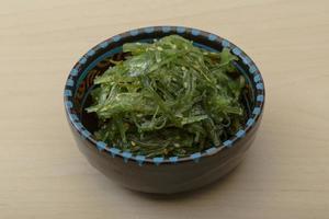 chuka salade in een kom Aan houten achtergrond foto