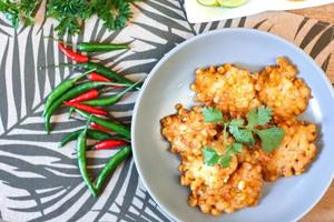 maïs beignets met Chili saus geplaatst Aan een houten tafel foto