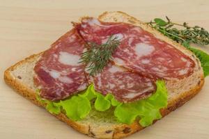 salami belegd broodje Aan houten achtergrond foto