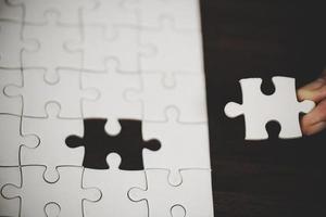 bedrijf vrouw persoon hand- met puzzel stuk idee voor strategie en oplossing. detailopname een deel van twee wit decoupeerzaag aansluiten samen. concept van toetreden samenwerking succes teamwork-probleem zakelijke team. foto