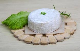 Camembert kaas Aan houten bord en houten achtergrond foto