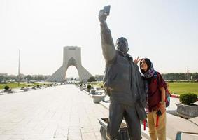 13e juni, 2022, Teheran , ik rende - vrouw zonder hijab houding voor selfie door beroemd ik rende monument in openbaar. azadi wandelen weg .vrouw protesteren in straten in ik rende foto