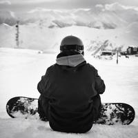 mannetje Mens snowboarder zitten genieten onder berg panorama in ski toevlucht alleen in majestueus bergen. foto