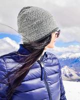 Kaukasische vrouwelijke persoon geniet van het panorama van de winterbergen in zonnig skigebied. rechts lege lege ruimte copypaste winter solo vakantie achtergrond foto