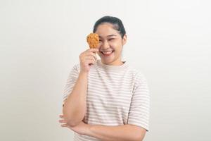 Aziatische vrouw met gebakken kip bij de hand foto