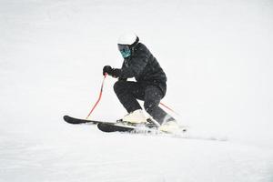 professioneel skiër Bij vol snelheid ski bergafwaarts Aan vers sneeuw Doen snijwerk in ski toevlucht terwijl opleiding voor wedstrijd in gudauri ski toevlucht in Georgië foto