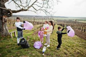 familie met vuilniszak die afval verzamelt tijdens het schoonmaken in de wijngaarden. milieubehoud en ecologie, recycling. foto