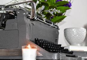 wijnoogst schrijfmachine met een kaars en bloemen foto