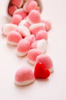 roze gelei of marshmallows met suiker op tafel foto