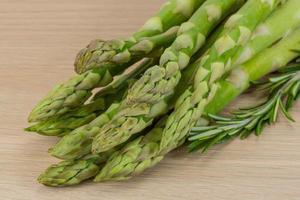 rauw asperges Aan houten achtergrond foto