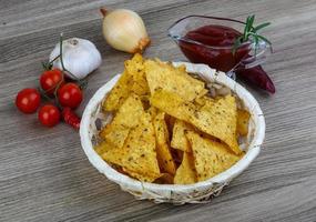 nacho's in een mand op houten achtergrond foto