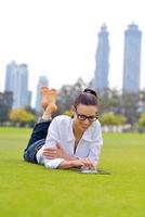 mooi jong vrouw met tablet in park foto