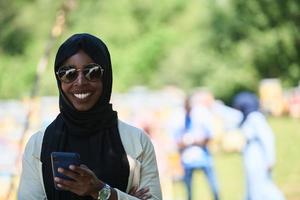 Afrikaanse vrouw gebruik makend van smartphone vervelend traditioneel Islamitisch kleren foto