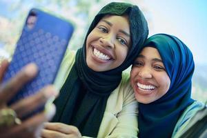 Afrikaanse vrouw vrienden gebruik makend van slim telefoon samen foto