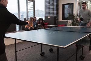 twee jong begin omhoog bedrijf Mens spelen tafel tennis Bij modern creatief kantoor ruimte mensen groep hebben vergadering en brainstorming in achtergrond foto