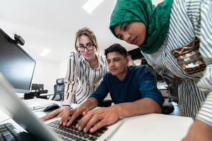 multi-etnisch opstarten bedrijf team Arabisch vrouw vervelend een hijab Aan vergadering in modern Open plan kantoor interieur brainstormen, werken Aan laptop en bureaublad computer. selectief focus foto