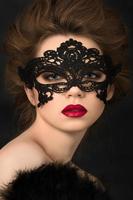 portret van jonge schattige vrouw in zwarte partij masker foto