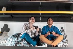 werk moeilijk Speel moeilijk. arbeiders spelen computer spellen Mens tegen vrouw gedurende breken in ontspanning Oppervlakte Bij creatief opstarten kantoor foto