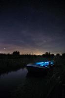 blauwe en witte boot verlicht op de rivier foto
