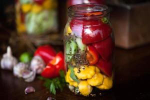 geconserveerde komkommers, paprika's en patisson in potten foto