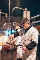 oud Mens Koken worstjes Aan de straat foto