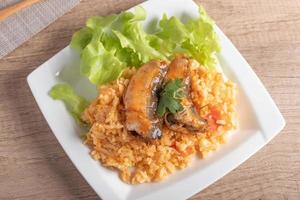 gebakken rijst met ingeblikte vis in een witte plate.thai food foto