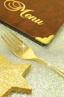gouden vork en restaurantmenu op feestelijke achtergrond foto