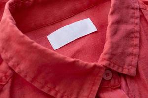 wit blanco kleding label etiket Aan rood linnen overhemd kleding stof structuur achtergrond foto