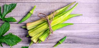 gezond groenten van vers groen okra en blad okara Aan grijs achtergrond.top visie foto